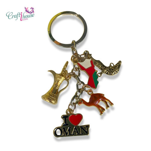 A high-polish metal keychain featuring the 'I Love Oman' logo in vibrant red, white, and green enamel.