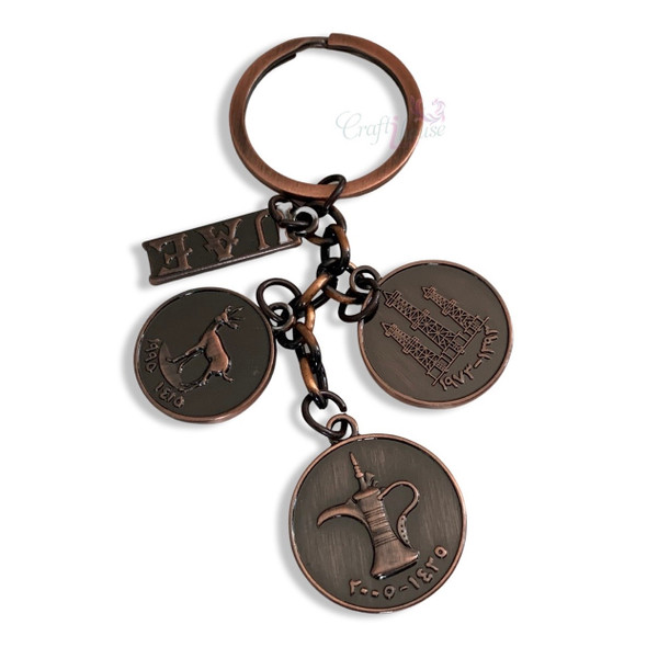 Close-up of the detailed engraving of the Arabic Dallah on the polished surface of the Dubai souvenir key ring.