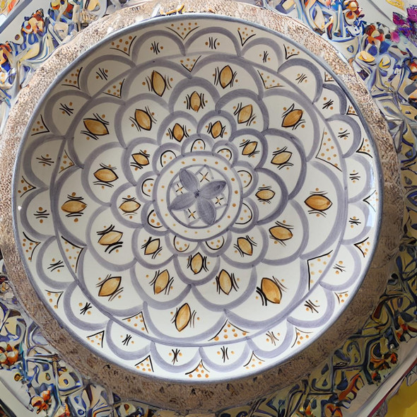 Detailed close-up of the complex glaze lines and brilliant mineral color fields on a hand-painted Moroccan serving dish.