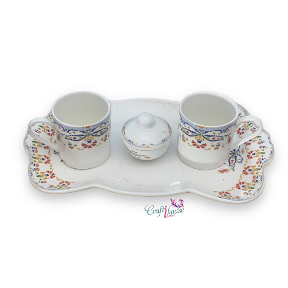 A professional product shot of the ceramic coffee cup set with tray and matching sugar bowl on a textured wooden surface.