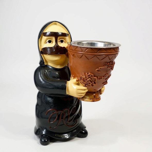 Close-up view of the detailed facial features, traditional attire, and ornate incense bowl on an Omani figurine.