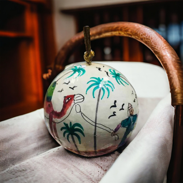 Close-up of the brushstrokes and vibrant desert sunset colors on the hand-painted UAE souvenir ornament.