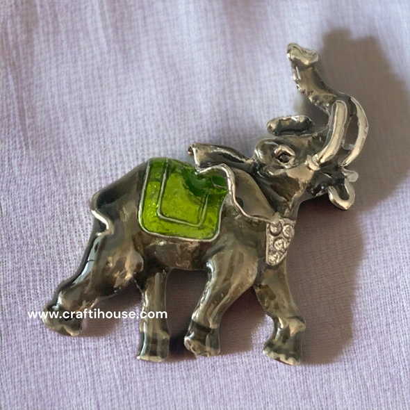 Detailed view of a silver-tone metal elephant magnet, showcasing subtle rhinestone accents and intricate craftsmanship.
