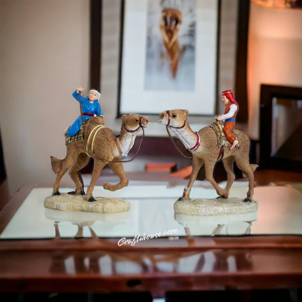 A premium set of 2 resin camel rider statues titled "The Caravan Duo" featuring detailed desert-inspired figures and a metallic finish.