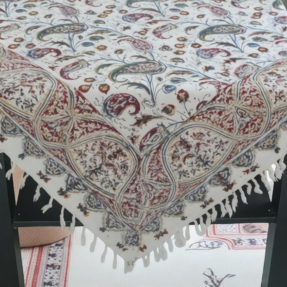 A premium 100x100 cm handmade cotton tablecloth titled "The Nomad’s Square" featuring a rustic woven boho pattern and fringed edges.