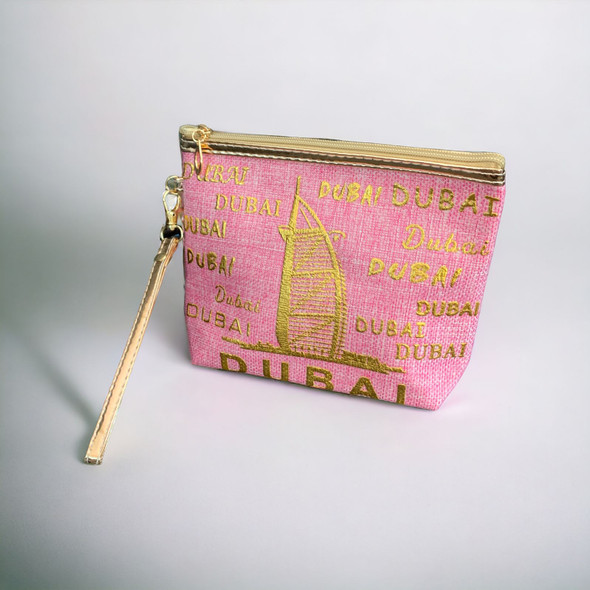A professional room setting presentation shot of the pink Dubai pouch showcasing its chic color palette and portable wristlet design.