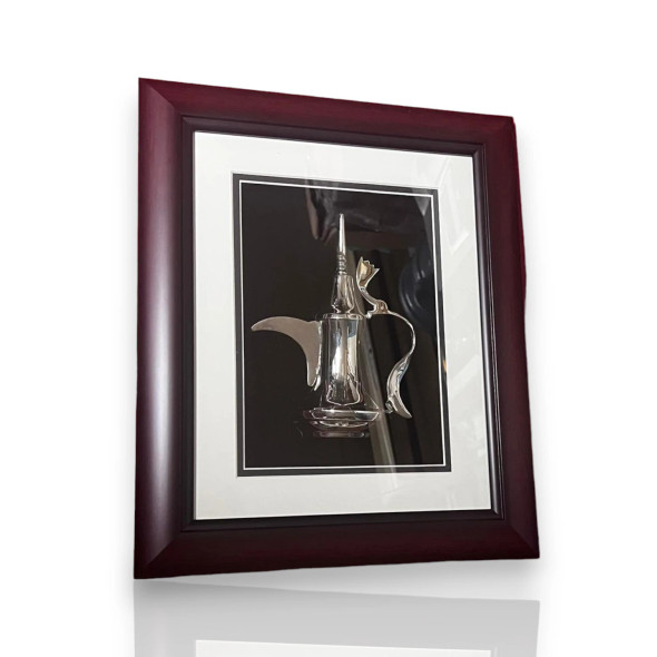 A professional product shot of the silver Dallah framed artwork resting on a rustic wooden table surface.
