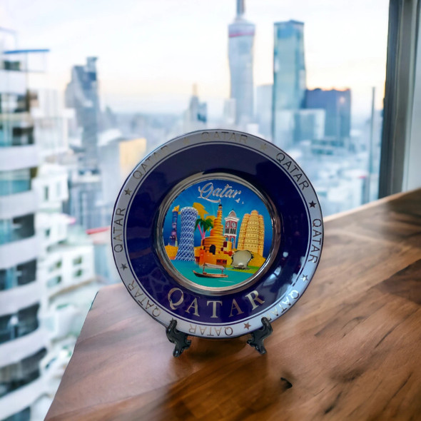 A professional product presentation of the 15 cm blue and gold Qatar decorative plate in an urban setting.