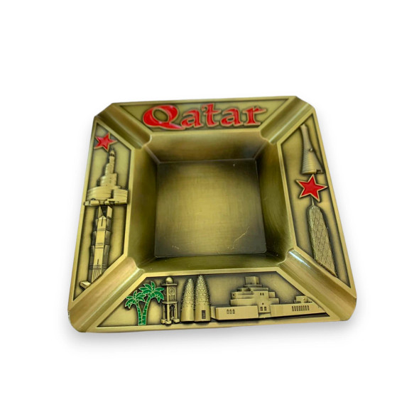 Detailed view of the decorative metal ashtray showcasing prominent Qatari architecture.
