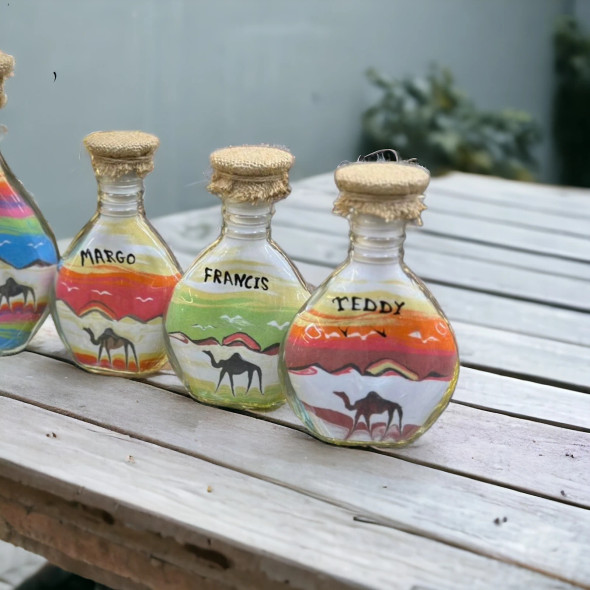 personalized sand art bottle, highlighting its sleek flared glass silhouette and securely sealed cork top.