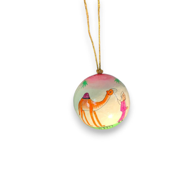 Close-up of a 3" paper mache ornament with traditional camel and traveler motif and gold hanging cord.