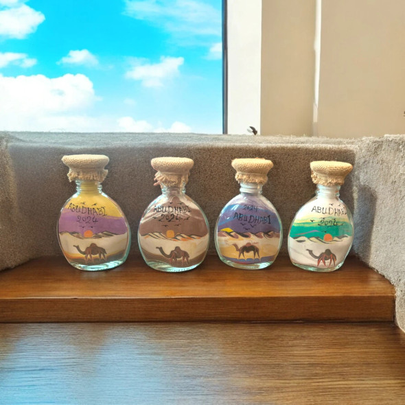 Close-up of the intricate sand layering and camel silhouettes inside a 13 cm Abu Dhabi keepsake bottle.