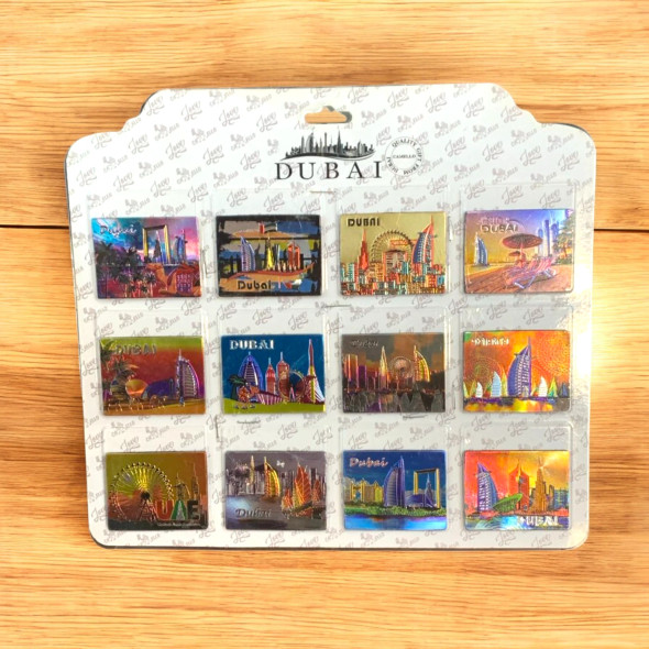 Complete presentation of the premium set of 12 printed foil Dubai souvenir magnets, showcasing a collection of gleaming, vibrant city landmark designs arranged elegantly.