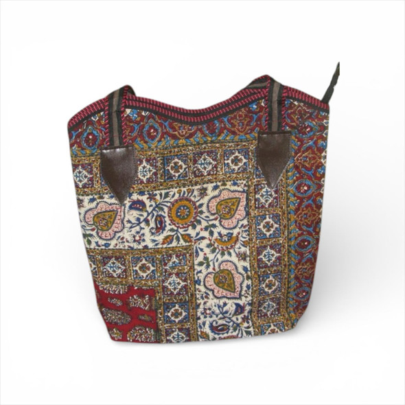 A large handmade cotton shopping bag featuring a colorful hand block-printed floral and geometric pattern with long shoulder straps.