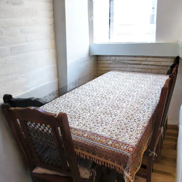 A heavy tapestry cotton tablecloth featuring a rich floral woven pattern on a dining table