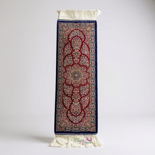 red silk carpet runner with an intricate Oriental floral pattern displayed as a centerpiece on a long dining table.