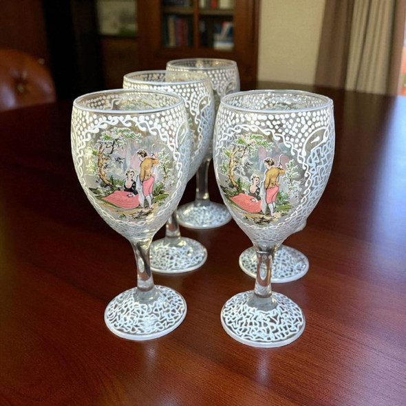 A pair of hand-painted wine glasses displayed on a table, ideal for creating a romantic or celebratory atmosphere during dinner.