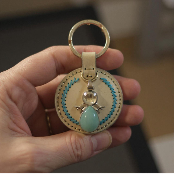 An exclusive Craftihouse accessory, showcasing the refined craftsmanship of leather and the serene beauty of a stone angel charm.