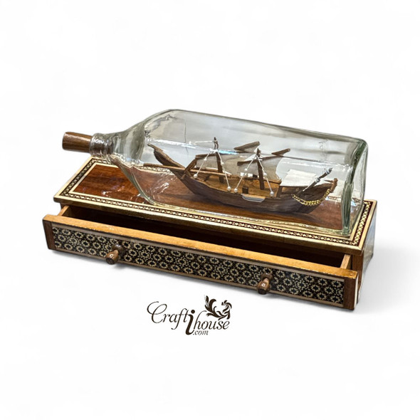 A sophisticated handmade Dhow ship in a bottle mounted on a Khatamkari wooden box, ideal for adding elegance to any office or living room desk.
