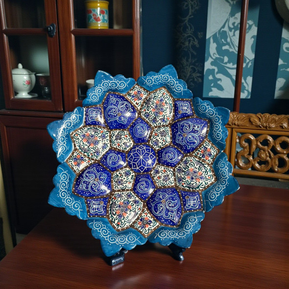 A professional product display shot of the 16 cm cobalt blue floral Minakari copper plate positioned against a dark teal wall background.