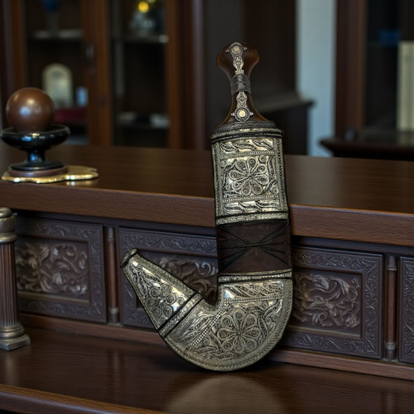 Detailed embossed metal filigree and hand-stitched leather work on an authentic Middle Eastern dagger sheath.