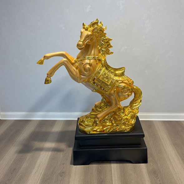 A 30cm rearing golden horse statue made of resin on a black rectangular base