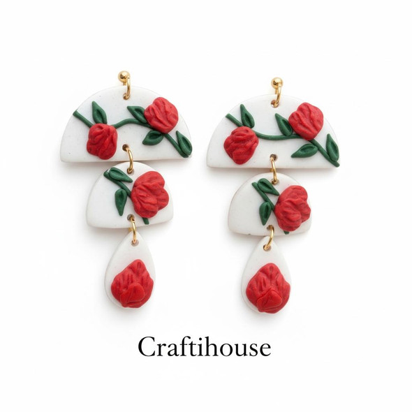 A pair of handcrafted three-tier earrings featuring textured teal pebble shapes and a center white drop with a blue botanical pattern.