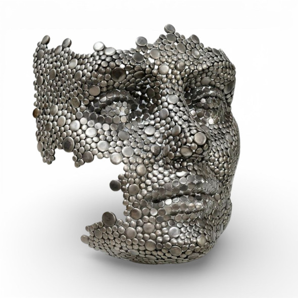 Close-up of the textured metal surface, highlighting the individual welded discs and the intricate craftsmanship of the face sculpture.