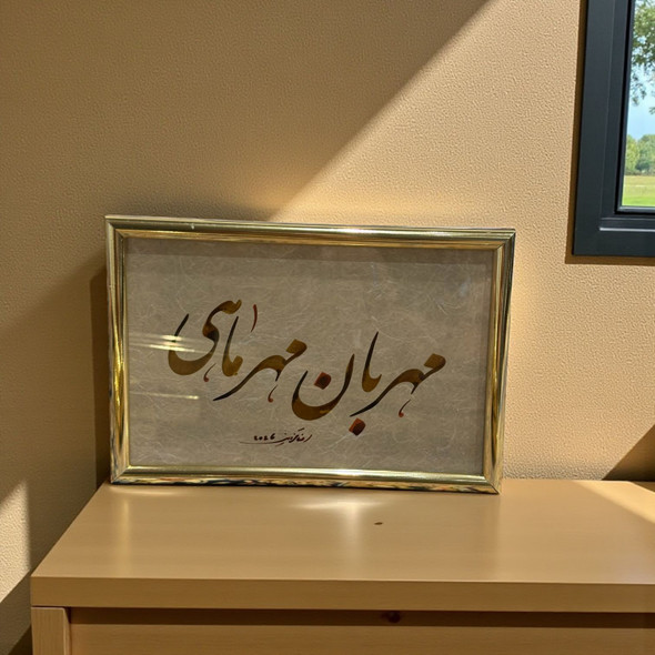 A framed Persian calligraphy artwork with gold and brown script on textured paper, set in a polished gold frame.