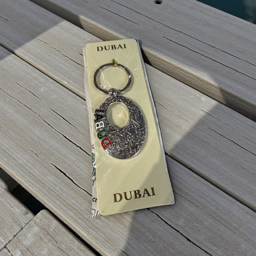 A rectangular silver-toned keychain featuring the embossed calligraphy architecture of Dubai's Museum of the Future.