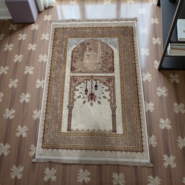 A full view of a beige and brown Islamic prayer rug featuring a Mihrab arch and hanging lantern motifs.