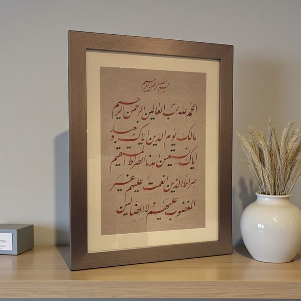A 65x45 cm framed original Islamic calligraphy art piece of Surah Al-Fatiha displayed on a wooden shelf.