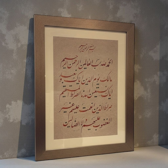 Close-up of the reddish-brown hand-scripted ink and textured paper of the original Surah Al-Fatiha calligraphy.