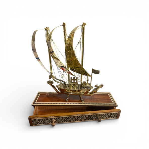 Close-up of the polished brass sails and deck details of the dhow, positioned as a premium retirement gift.