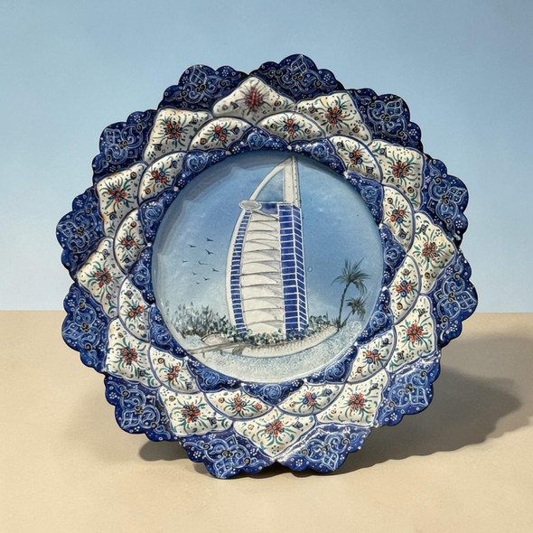A 20 cm hand-painted Minakari copper plate featuring a Burj Al Arab and palm tree central pattern with a blue floral border.