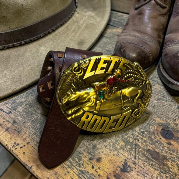 A premium handmade natural leather belt in a rich tan color featuring a stunning 3D golden cowboy horse rider buckle.