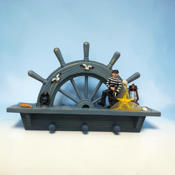 A detailed close-up highlighting the seated sailor figurine in a striped shirt, yellow starfish in a fishing net, vintage lanterns, and distressed blue wood finish