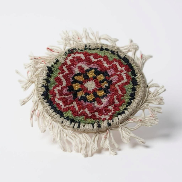 A collection of round 10 cm woven carpet coasters featuring traditional UAE-inspired patterns and colors.