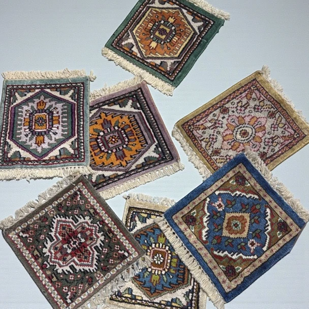 A 30x28 cm handmade miniature carpet featuring a detailed assorted oriental pattern with fringed ends.
