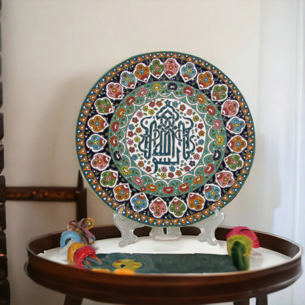 A premium 25 cm handmade clay plate featuring intricate Islamic calligraphy surrounded by a vibrant, multi-colored floral mosaic for wall decor.