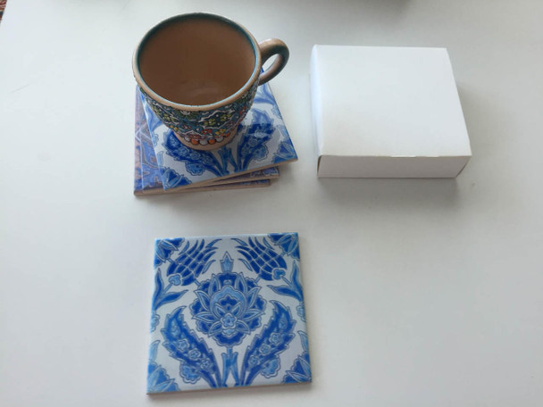 Close-up of a square ceramic coaster displaying the intricate, symmetric blue and white floral artwork characteristic of traditional Persian design.