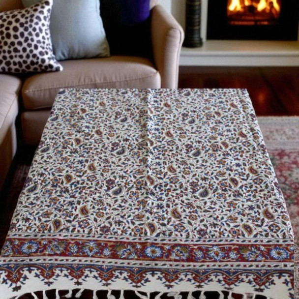 A square Persian block-print cloth used as a decorative overlay on a larger white dining table