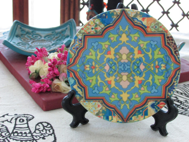 A premium ceramic coaster featuring a vibrant and intricate traditional floral Arabesque pattern in yellow and turquoise.