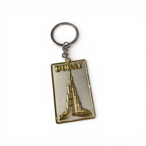 A gold-plated keychain with a central "I Love Dubai" medallion and three dangling charms of famous Dubai landmarks.
