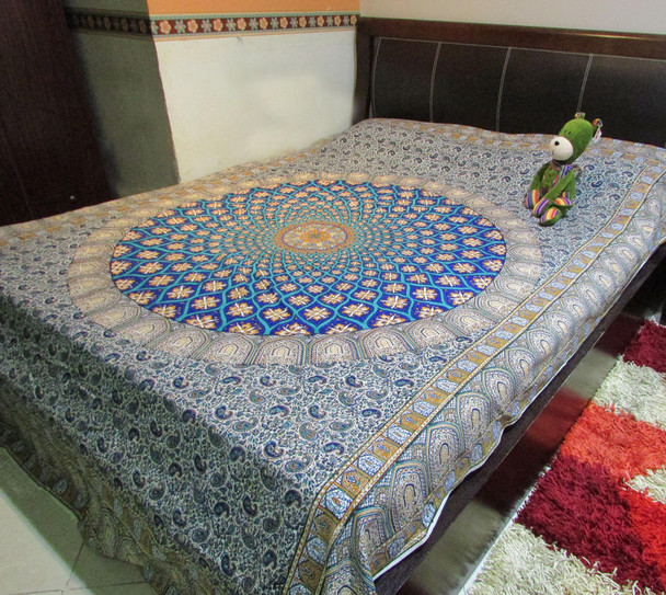 A vibrant 280x180 cm artisan cotton bedsheet featuring a striking blue central Ghalamkari medallion, intricate paisley patterns, and traditional borders.