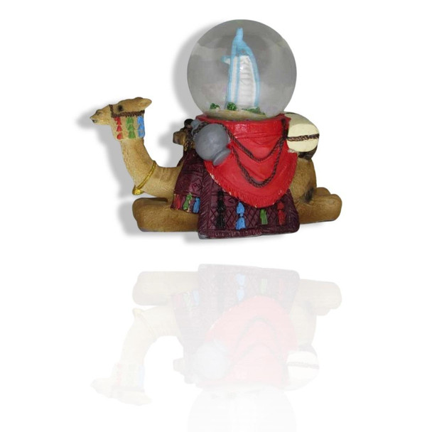 The detailed figurine of a decorated camel holding a Dubai landmark snow globe