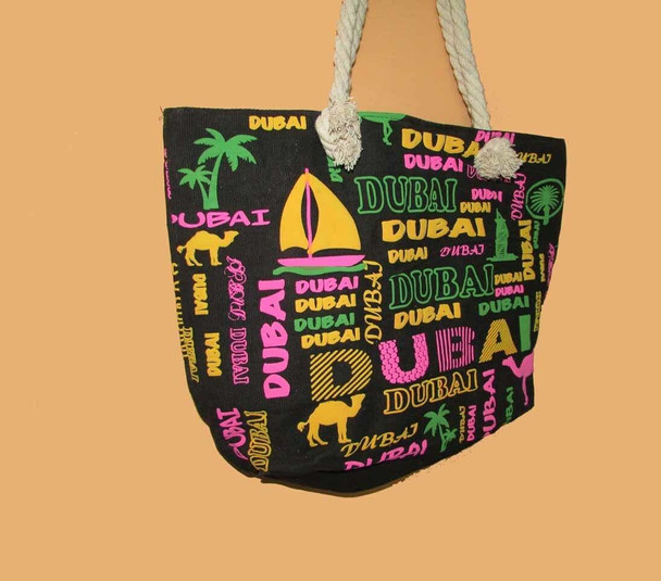 A black canvas tote bag featuring colorful "Dubai" text, camels, palm trees, and a sailboat print