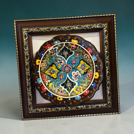 An 18 cm hand-painted Turkish ceramic plate with vibrant floral relief patterns, mounted in a 27x27 cm white frame.