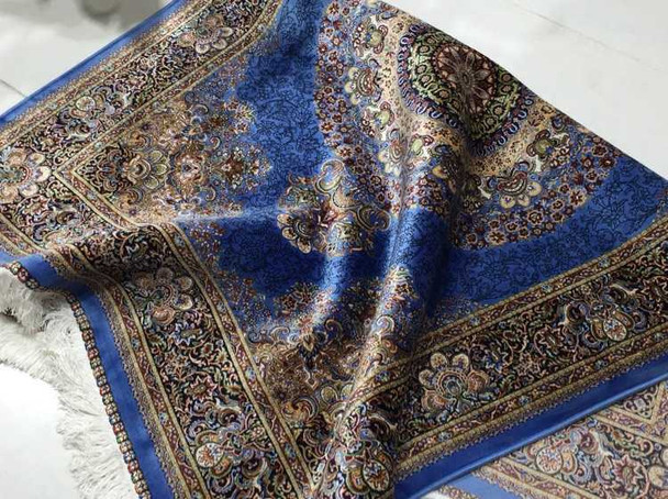 A 150x100 cm sapphire blue silk-touch rug with a traditional floral medallion shimmering in a modern luxury bedroom.