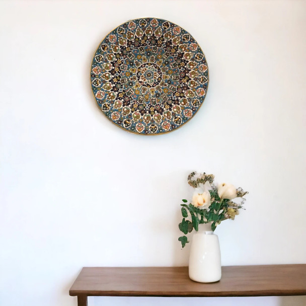 A monumental 40 cm handmade clay plate featuring vibrant embossed enamel patterns and a high-gloss protective glaze.